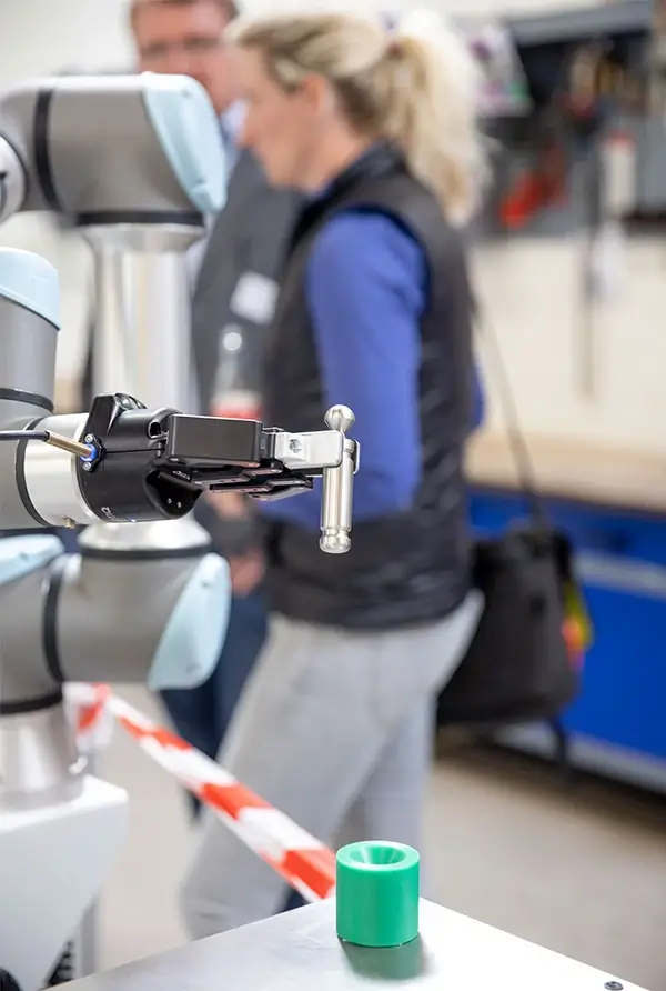 Cobot von Universal Robots hält Flaschenöffner in der Hand